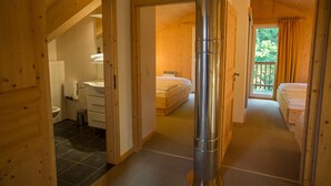 Et træinteriør med badeværelse, seng og en stor, rund genstand.