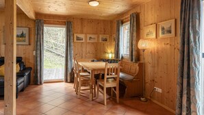 Un intérieur en bois comprenant une table à manger, des chaises, un canapé et un lampadaire.