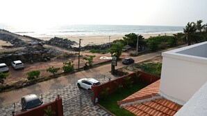 Un quartier résidentiel offrant une vue sur la plage, avec des voitures garées et une entrée sécurisée par un portail.