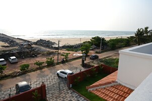 Zona residencial con vista a la playa, coches aparcados y entrada con portón.