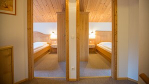 A room with two wooden beds, a carpeted floor, and a wooden ceiling. - Chalet # 43 with 3 BR for up to 6 people (Annaberg)