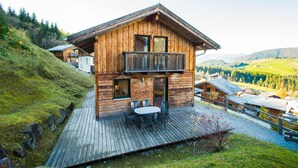 A wooden cabin with a balcony, a deck, and a view of the surrounding landscape. - Chalet # 43 with 3 BR for up to 6 people (Annaberg)