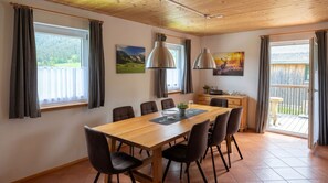 A dining area with a wooden table, chairs, and pendant lights. - Chalet # 53 with 3 BR for 6 to 8 people (Annaberg)