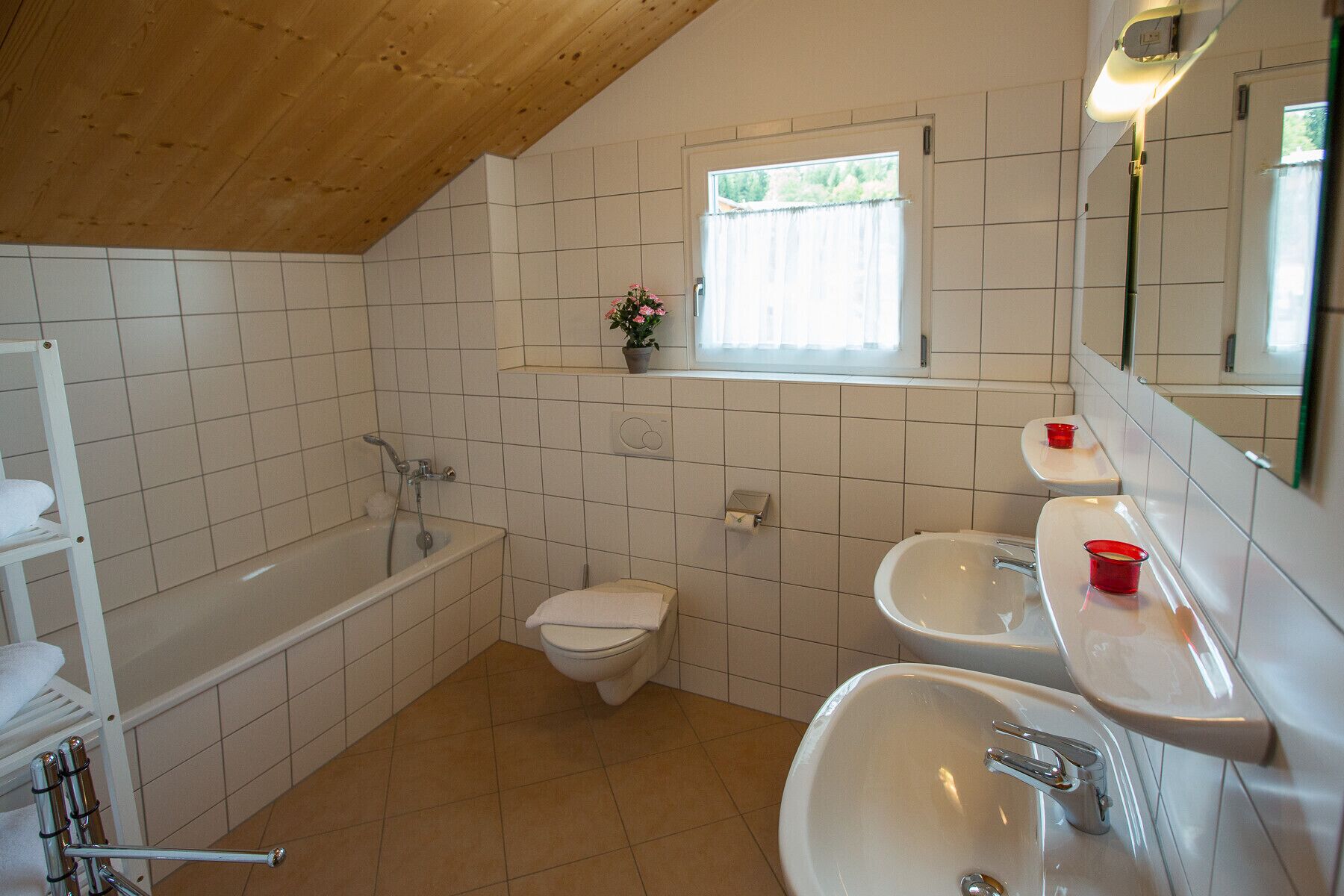 A bathroom with a bathtub, toilet, and two sinks.