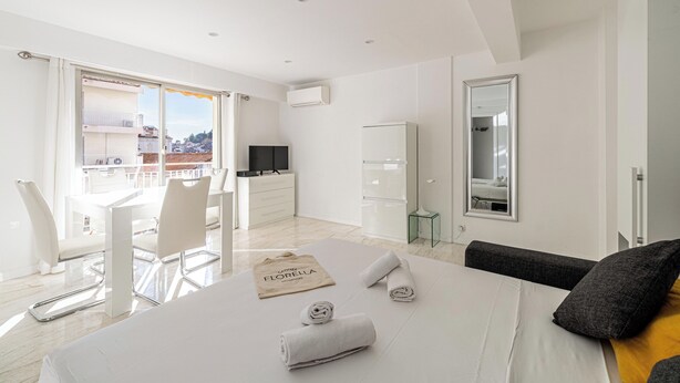 Una habitación de hotel moderna con cama, escritorio, silla, televisión y balcón con vistas.