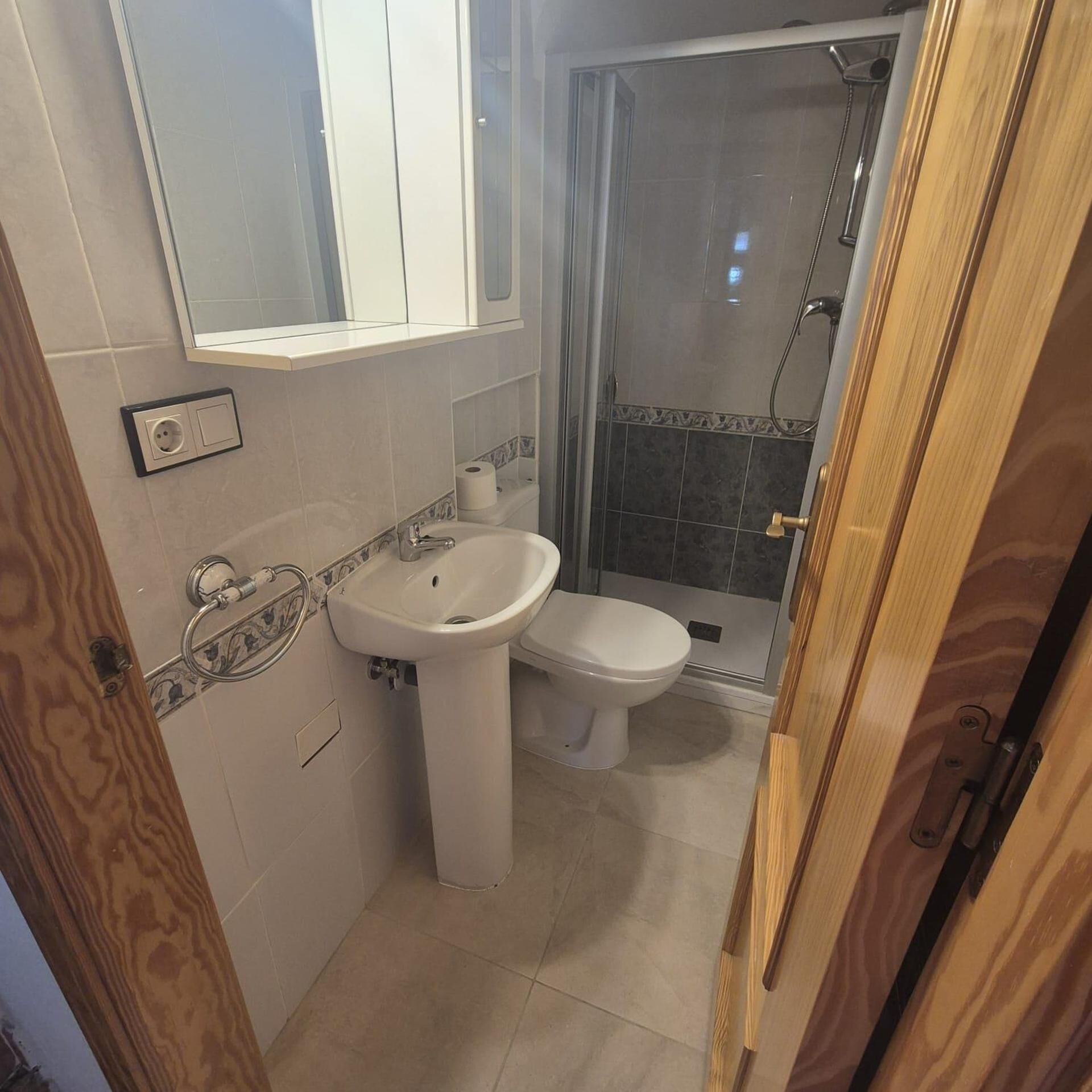 A bathroom with a sink, toilet, and shower.