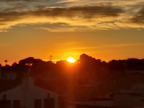 Un atardecer sobre un paisaje urbano con edificios recortados contra el cielo.