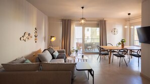 Una sala de estar moderna con un sofá, una mesa de centro y un comedor con sillas y una mesa.