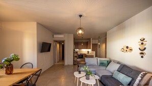 Una sala de estar moderna con un sofá, una mesa de centro y una zona comedor con una mesa y sillas.