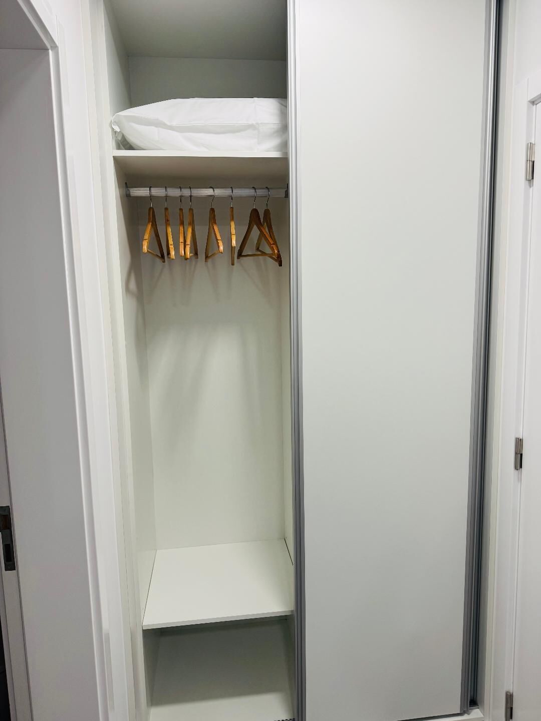 Un vestidor con barra para colgar y estante.