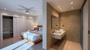 Un dormitorio moderno con cama, vestidor y baño con tocador y espejo.