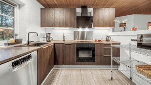 Una cocina moderna con armarios de madera, electrodomésticos de acero inoxidable y un horno empotrado.