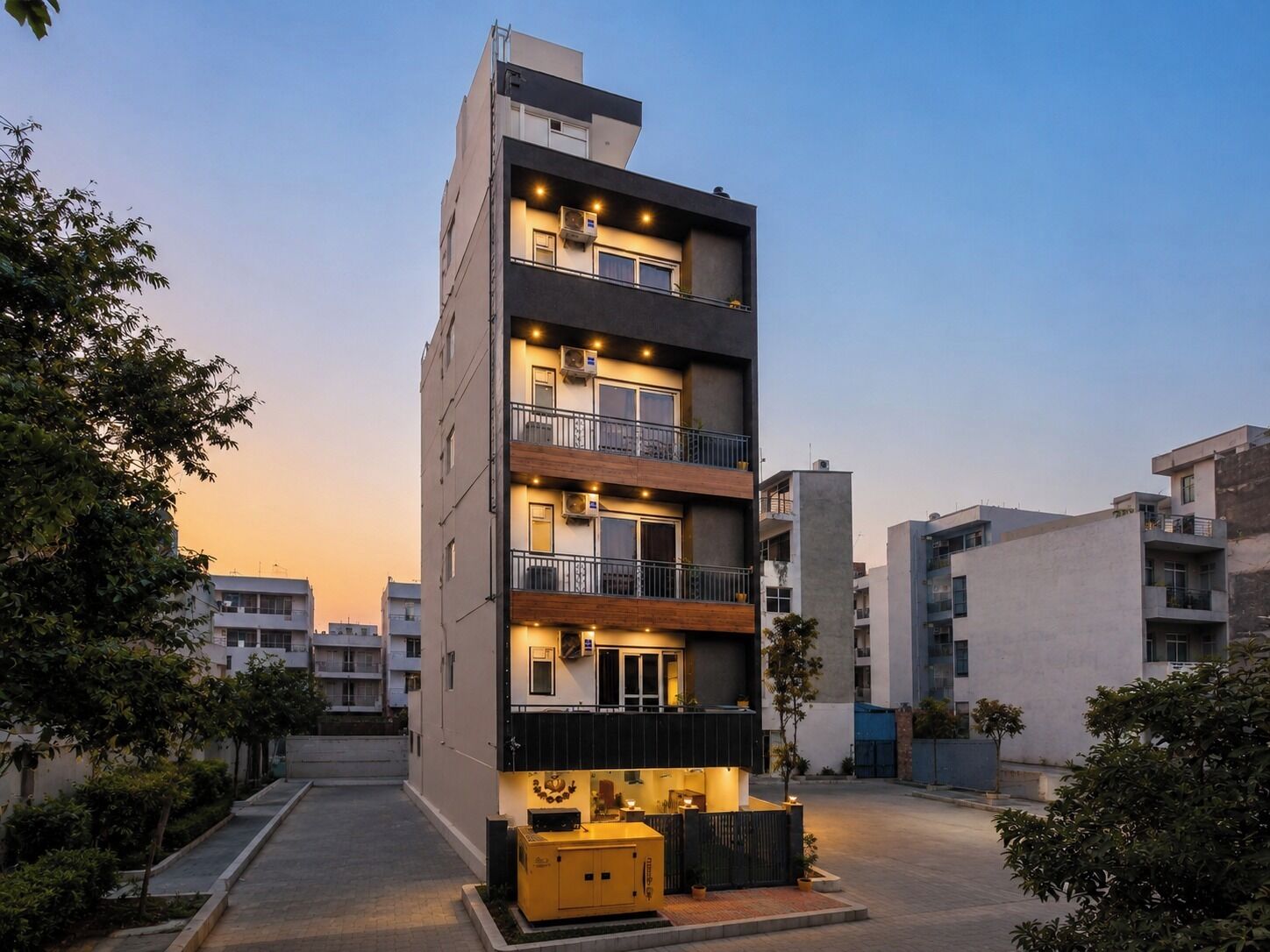 Un edificio residencial de varios pisos con balcones, garaje y una entrada bien iluminada.