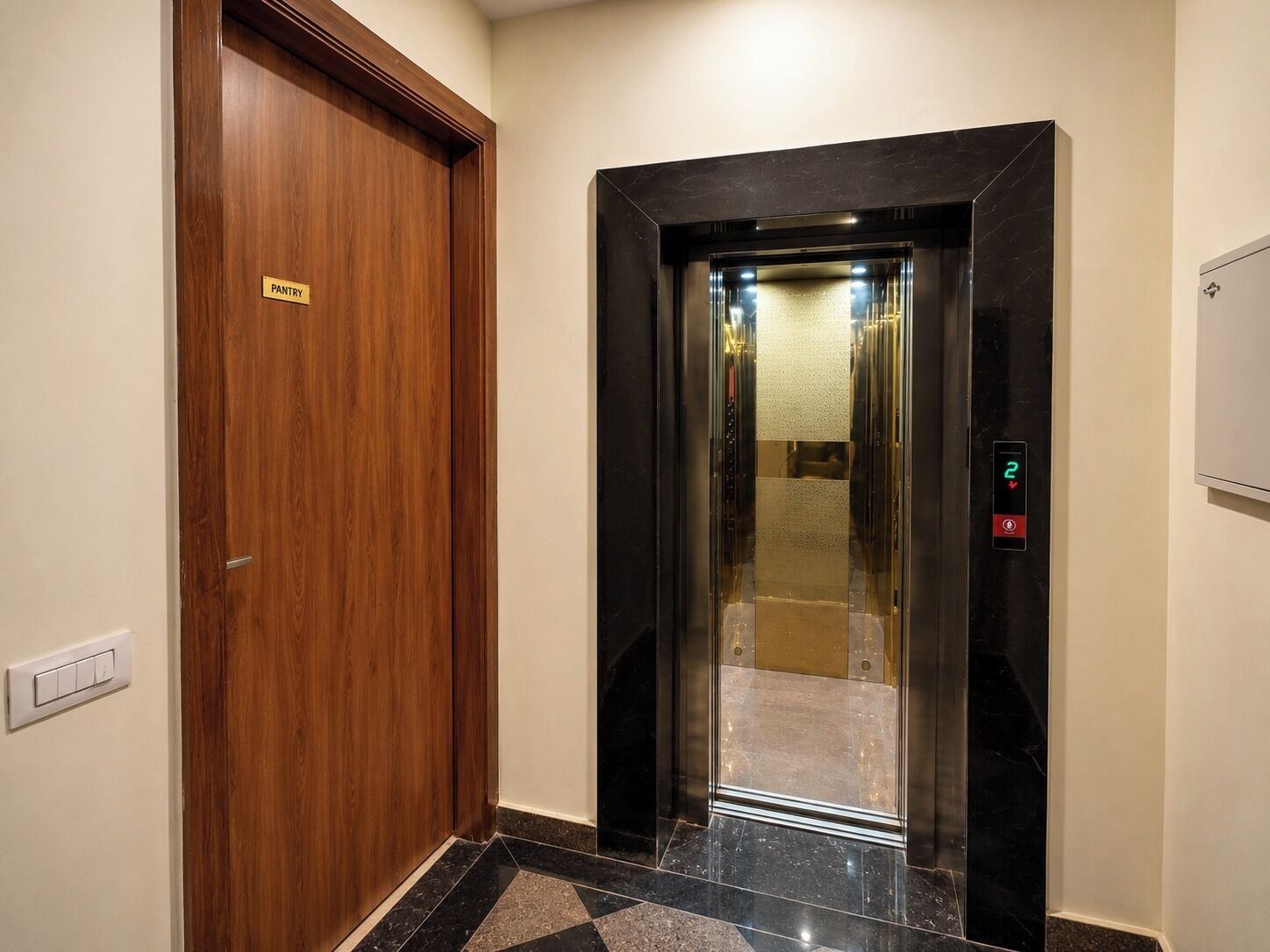 A hallway with a wooden door labeled 'PANTRY' and a modern elevator with a digital display.
