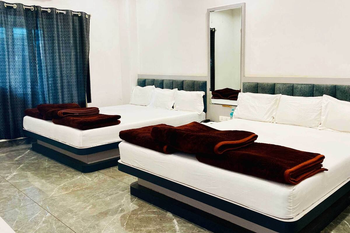 Ein Hotelzimmer mit zwei Betten, jeweils mit weißer Bettwäsche und braunen Handtüchern.