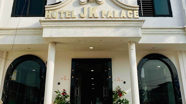 A white building with a central entrance, columns, and a sign reading "HOTEL JK PALACE". - Hotel JK Palace (Khandwa)