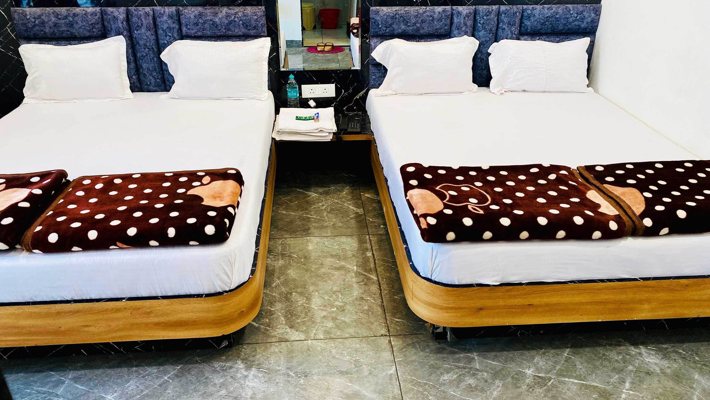 Two twin beds with wooden frames and white bedding, each with a polka-dotted blanket.