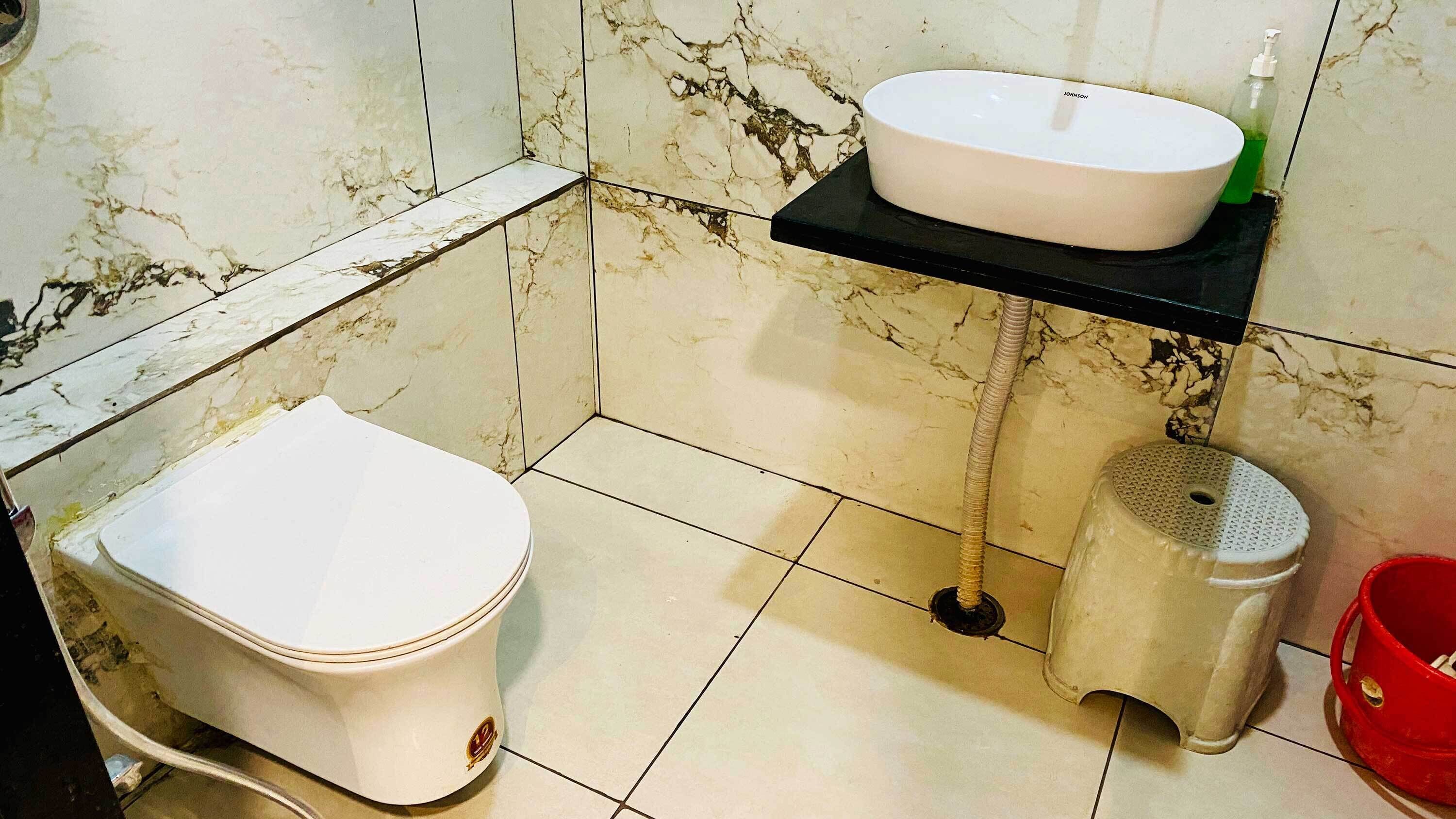 A bathroom with a toilet, a sink, and a bidet.