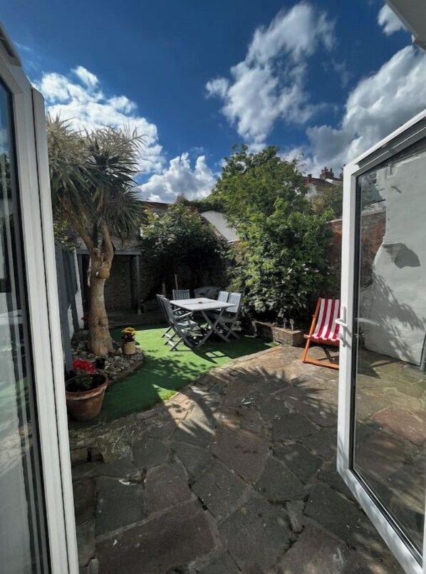Enjoy meals and conversations in this outdoor space with a patio area, table, and chairs.