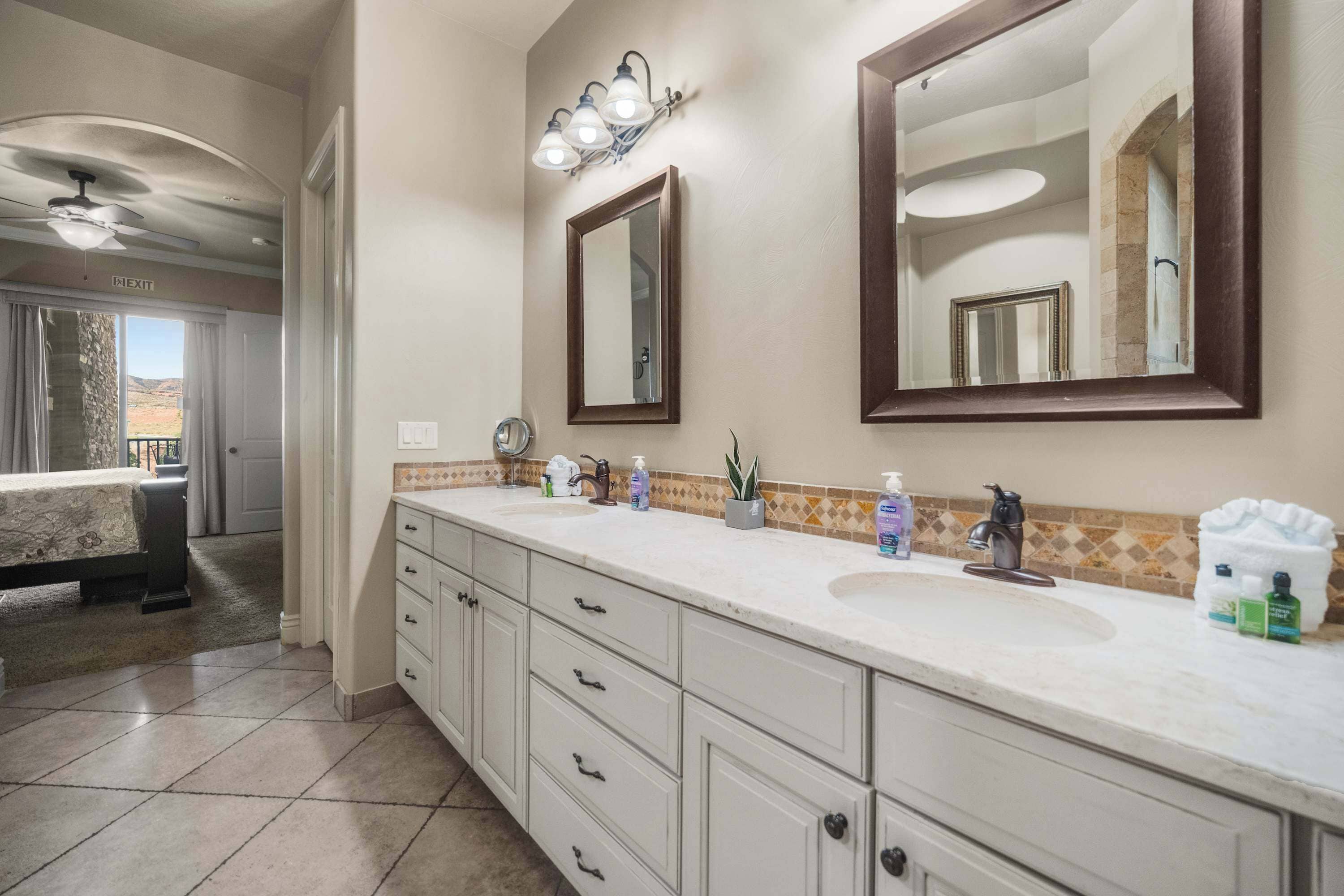 Une salle de bain avec un grand miroir, un lavabo et un meuble-lavabo doté de tiroirs.