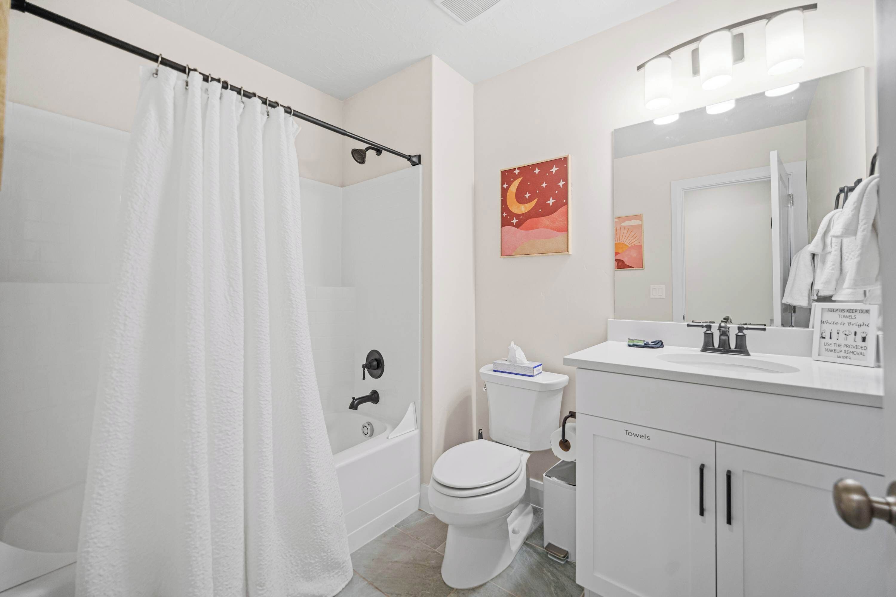 Un baño con ducha, inodoro, lavamanos y tocador.