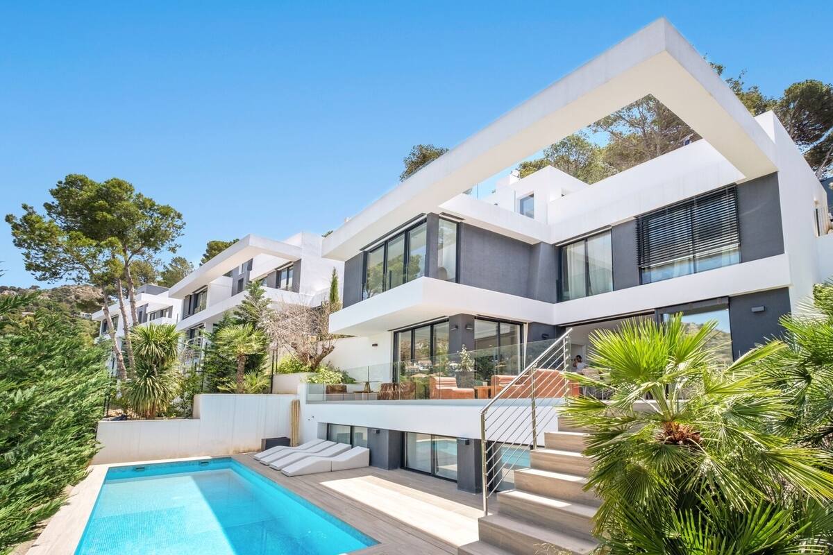 Ein modernes, mehrgeschossiges Haus mit Swimmingpool, Sitzgelegenheiten im Freien und üppiger Bepflanzung.