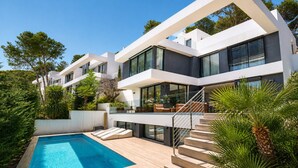 A modern multi-story house with a swimming pool, outdoor seating, and lush greenery. - Villas Pinares de San Antón, Saltwater pool, Sea, City, Mountain Views (Málaga)