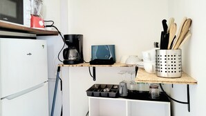 A compact kitchen with a microwave, coffee maker, and storage shelves. - Renovated seafront studio in Canet, near amenities, ideal for 3 people (Canet-en-Roussillon)