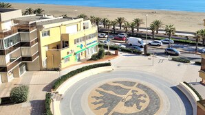 A building with a medical facility, a parking area, and a beach view. - Renovated seafront studio in Canet, near amenities, ideal for 3 people (Canet-en-Roussillon)