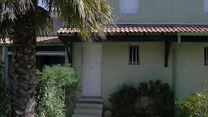 A building with a tiled roof, a white door, and a small set of steps leading to the entrance. - Air-conditioned pavilion with pool, near beach, 2 bedrooms (Valras-Plage)