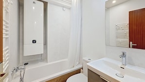 A modern bathroom with a bathtub, toilet, and sink. - La Clusaz: 31m² Apartment, 4 people, South Balcony (La Clusaz)