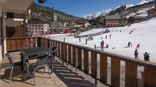 A balcony with outdoor seating overlooking a ski resort. - La Clusaz: Studio 4 pers, Balcony, Wifi, Pets allowed (La Clusaz)