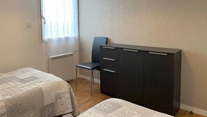 Ein Schlafzimmer mit einem Bett, einem Schreibtisch und einem Stuhl.