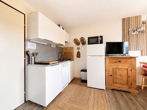 A compact kitchen with white cabinetry, a microwave, a refrigerator, and a wooden cabinet with a television. - Modern and bright studio with views of Mont Charvin. Private parking (Notre-Dame-de-Bellecombe)