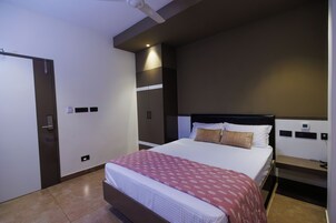 A modern bedroom with a bed, bedside tables, a wardrobe, and a ceiling fan.