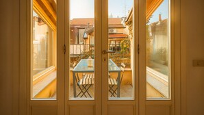 Vista a través de puertas de cristal que dan a un patio exterior con una mesa y sillas.