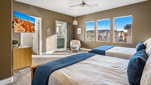 A bedroom with two beds, a ceiling fan, a TV, and a view of the neighborhood. - Zion Village 251|Private Pool, Xbox, Grill, Resort Amenities, and more! (Hurricane)
