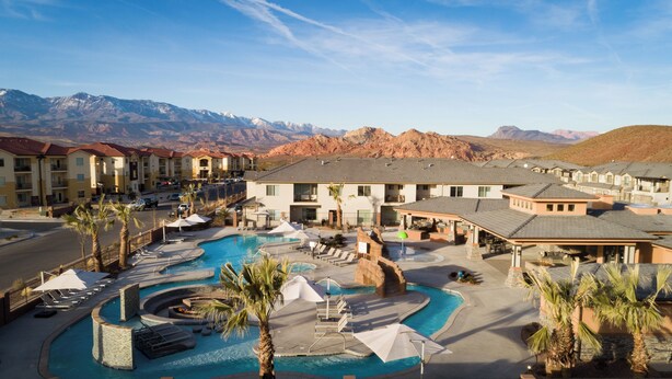 A resort with multiple buildings, a central swimming pool, and a mountainous backdrop. - Zion Village 251|Private Pool, Xbox, Grill, Resort Amenities, and more! (Hurricane)
