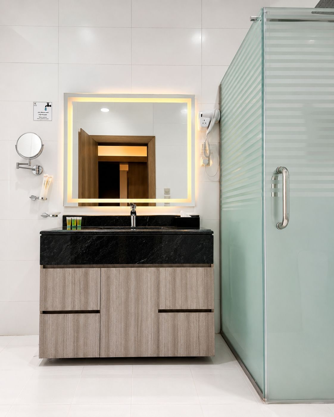 A modern bathroom with a vanity, mirror, and a glass shower enclosure.