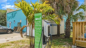 A parking area with a sign indicating reserved parking for electric vehicles and charging stations.