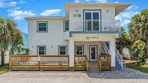 A two-story building with a balcony, a staircase, and a gated entrance.