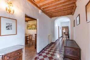 Un pasillo con piso a cuadros, muebles de madera y obras de arte enmarcadas en las paredes.