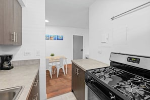 A compact kitchen with a stove, sink, and cabinets. - Miami Beach Apartment: Beach Access & Family Fun! (Miami Beach)
