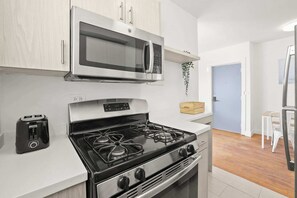A modern kitchen with a microwave, stove, and toaster.
