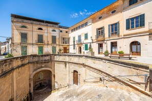 A historic building with a courtyard, stone archway, and a bench. - Charming Villa 'Cas Sitger' in the Heart of Felanitx – Garden, Terraces & Wi-Fi (Felanitx)