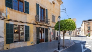 A building with a balcony, a fire hydrant, and a street lamp. - Charming Villa 'Cas Sitger' in the Heart of Felanitx – Garden, Terraces & Wi-Fi (Felanitx)