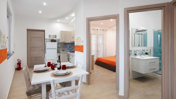 A compact living space with a dining area, kitchenette, and a bathroom with a shower. - Apartment 'Martina' with Mountain View, Wi-Fi and Air Conditioning (Agerola)
