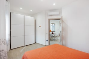 A bedroom with a bed, a wardrobe, and a bathroom visible through an open door.