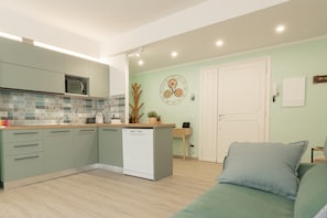 Una cucina moderna con lavastoviglie, forno a microonde e zoccolo paraschizzi in piastrelle.