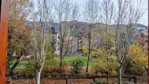 Vista de un edificio con fachada de piedra, rodeado de árboles y un área verde.